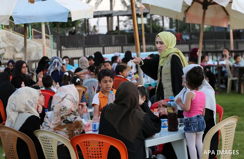 A picture taken on June 11, 2017 shows Palestinian Muslims eat their Iftar meal as they break their fast during the holy fasting month of Ramadan, at a park in Gaza city. Ramadan is sacred to Muslims because it is during...