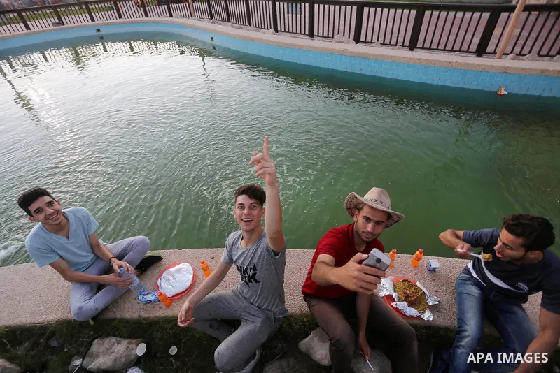 A picture taken on June 11, 2017 shows Palestinian Muslims eat their Iftar meal as they break their fast during the holy fasting month of Ramadan, at a park in Gaza city. Ramadan is sacred to Muslims because it is during...