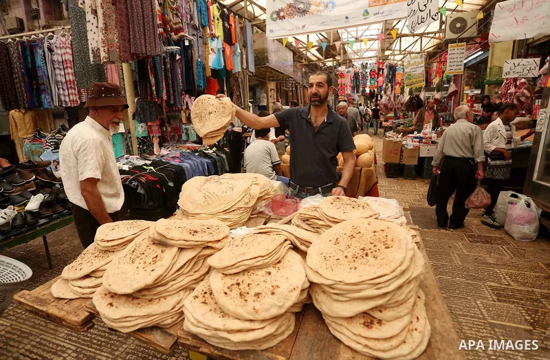 A Palestinian vendor sells bread at a market on the Muslim holy fasting month of Ramadan in the Old City of the West Bank town of Nablus, on June 13, 2017. Ramadan is sacred to Muslims because it is during that month tha...