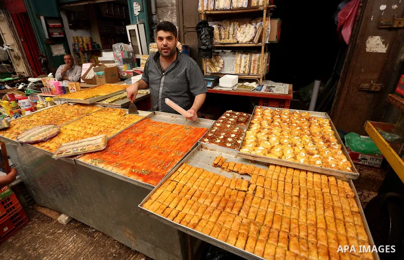 A Palestinian vendor preparers sweets at a market on the Muslim holy fasting month of Ramadan in the Old City of the West Bank town of Nablus, on June 13, 2017. Ramadan is sacred to Muslims because it is during that mont...