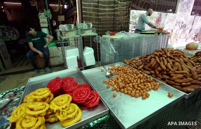 A Palestinian vendor preparers a traditional sweets at a market on the Muslim holy fasting month of Ramadan in the Old City of the West Bank town of Nablus, on June 13, 2017. Ramadan is sacred to Muslims because it is du...