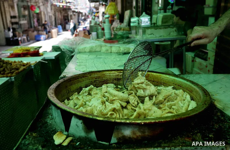 A Palestinian vendor preparers a traditional sweets at a market on the Muslim holy fasting month of Ramadan in the Old City of the West Bank town of Nablus, on June 13, 2017. Ramadan is sacred to Muslims because it is du...