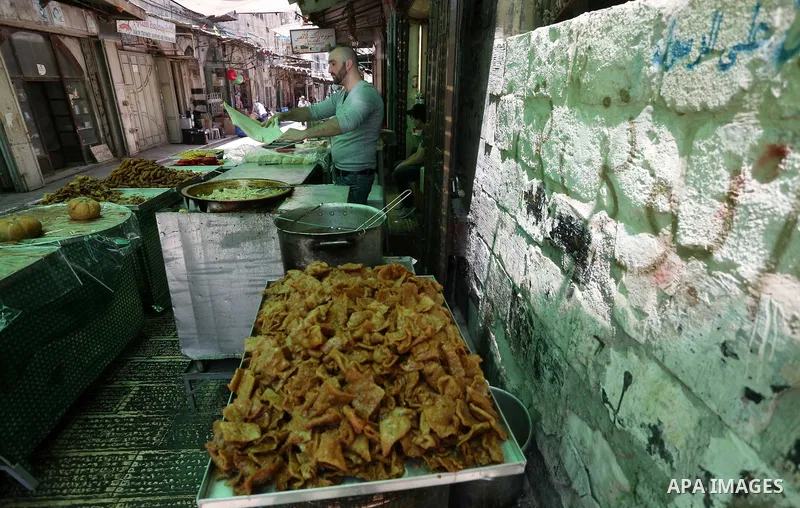 A Palestinian vendor preparers a traditional sweets at a market on the Muslim holy fasting month of Ramadan in the Old City of the West Bank town of Nablus, on June 13, 2017. Ramadan is sacred to Muslims because it is du...