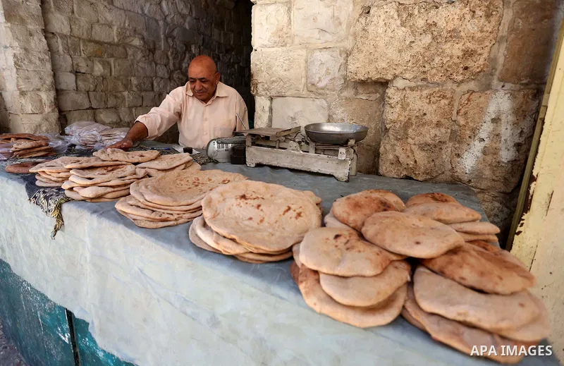 A Palestinian vendor sells bread at a market on the Muslim holy fasting month of Ramadan in the Old City of the West Bank town of Nablus, on June 13, 2017. Ramadan is sacred to Muslims because it is during that month tha...