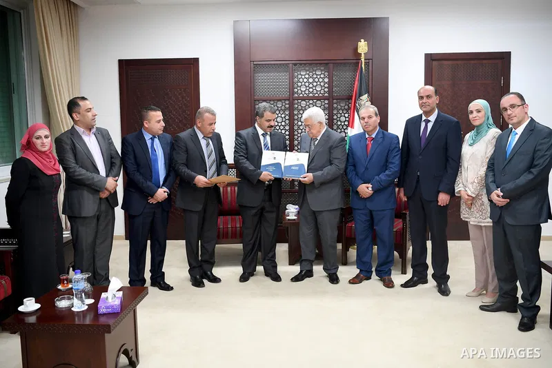 Palestinian President Mahmoud Abbas receives the annual report of the Financial and Administrative Management Bureau, in the West Bank city of Ramallah on June 13, 2017. Photo by Osama Falah