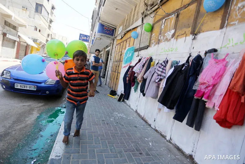 A Palestinian boy looks at second hand clothes attached on the wall at street for poor people, on the Muslim holy fasting month of Ramadan, on Gaza city on June 14, 2017. Ramadan is sacred to Muslims because it is during...
