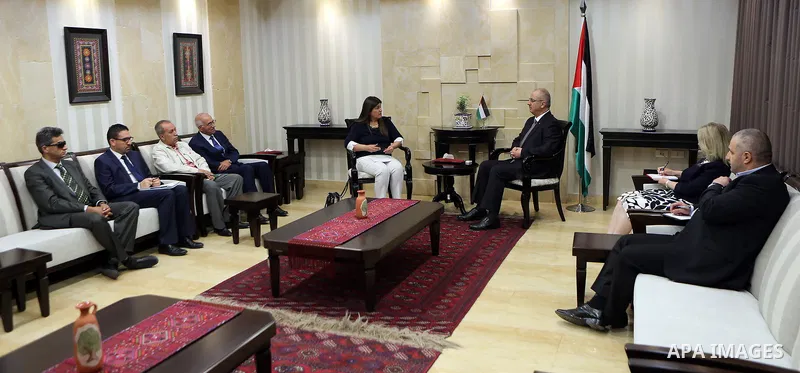 Palestinian Prime Minister Rami Hamdallah receives the annual report of the Independent Commission on Human Rights for 2017, at his office in the West Bank city of Ramallah on June 14, 2017. Photo by Prime Minister Offic...