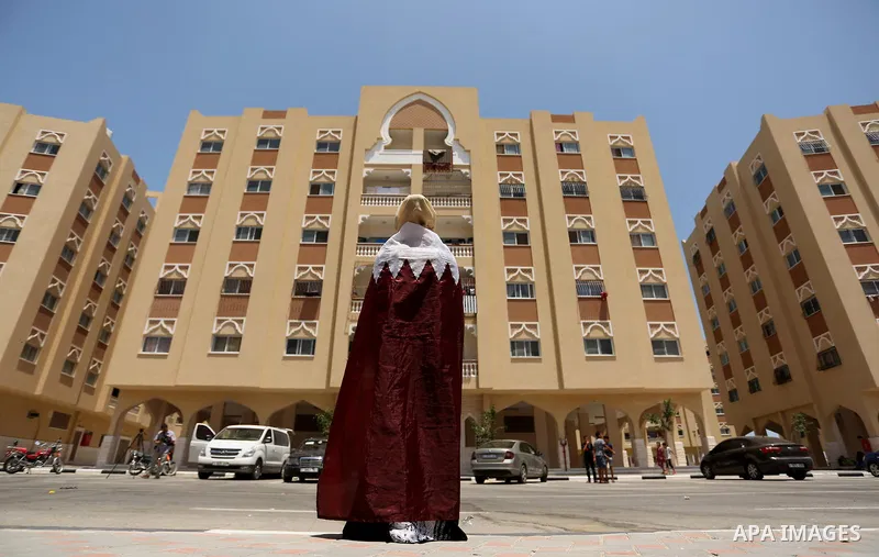 A Palestinian woman wears Qatari flag in a rally in support of Qatar, inside Qatari-funded construction project 'Hamad City', in Khan Younis in the southern Gaza Strip, June 14, 2017. Photo by Ashraf Amra