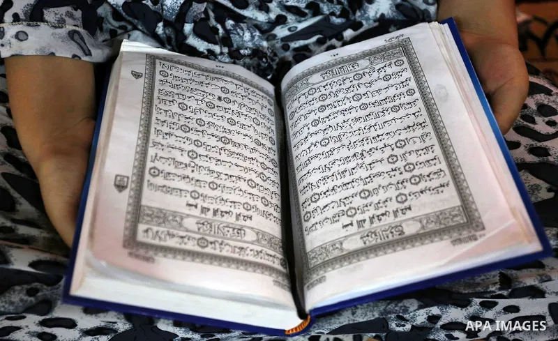 A Palestinian girl reads a copy of the Koran, Islam's holiest book, on the Muslim holy fasting month of Ramadan, at Hamad Mosque in Khan Younis in the southern Gaza Strip, June 14, 2017. Ramadan is sacred to Muslims beca...