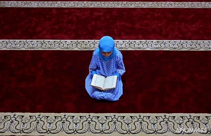 A Palestinian girl reads a copy of the Koran, Islam's holiest book, on the Muslim holy fasting month of Ramadan, at Hamad Mosque in Khan Younis in the southern Gaza Strip, June 14, 2017. Ramadan is sacred to Muslims beca...
