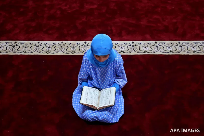 A Palestinian girl reads a copy of the Koran, Islam's holiest book, on the Muslim holy fasting month of Ramadan, at Hamad Mosque in Khan Younis in the southern Gaza Strip, June 14, 2017. Ramadan is sacred to Muslims beca...