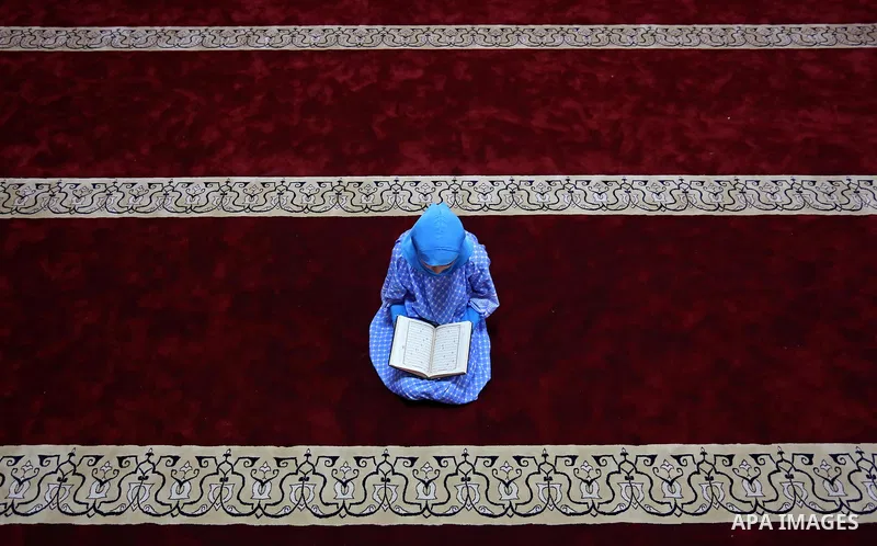 A Palestinian girl reads a copy of the Koran, Islam's holiest book, on the Muslim holy fasting month of Ramadan, at Hamad Mosque in Khan Younis in the southern Gaza Strip, June 14, 2017. Ramadan is sacred to Muslims beca...