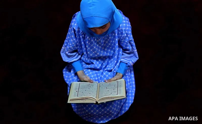 A Palestinian girl reads a copy of the Koran, Islam's holiest book, on the Muslim holy fasting month of Ramadan, at Hamad Mosque in Khan Younis in the southern Gaza Strip, June 14, 2017. Ramadan is sacred to Muslims beca...
