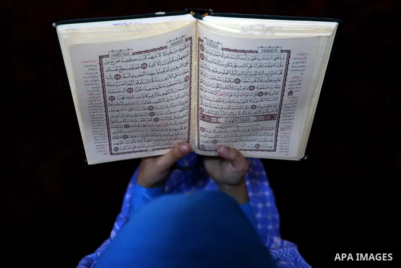 A Palestinian girl reads a copy of the Koran, Islam's holiest book, on the Muslim holy fasting month of Ramadan, at Hamad Mosque in Khan Younis in the southern Gaza Strip, June 14, 2017. Ramadan is sacred to Muslims beca...