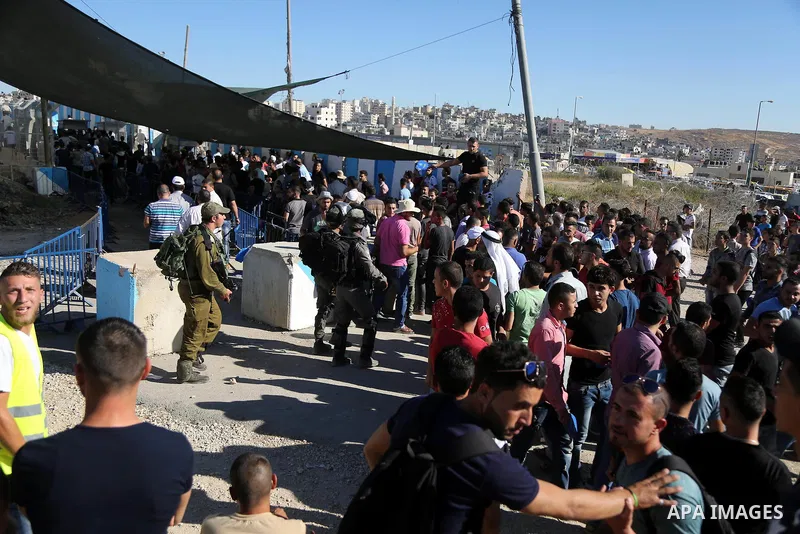 Palestinians make their way through the Israeli Qalandia checkpoint, in the occupied West Bank between Ramallah and Jerusalem, to attend Friday prayer of the holy fasting month of Ramadan in Jerusalem's al-Aqsa mosque, o...
