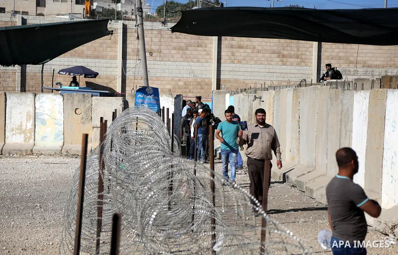 Palestinians make their way through the Israeli Qalandia checkpoint, in the occupied West Bank between Ramallah and Jerusalem, to attend Friday prayer of the holy fasting month of Ramadan in Jerusalem's al-Aqsa mosque, o...