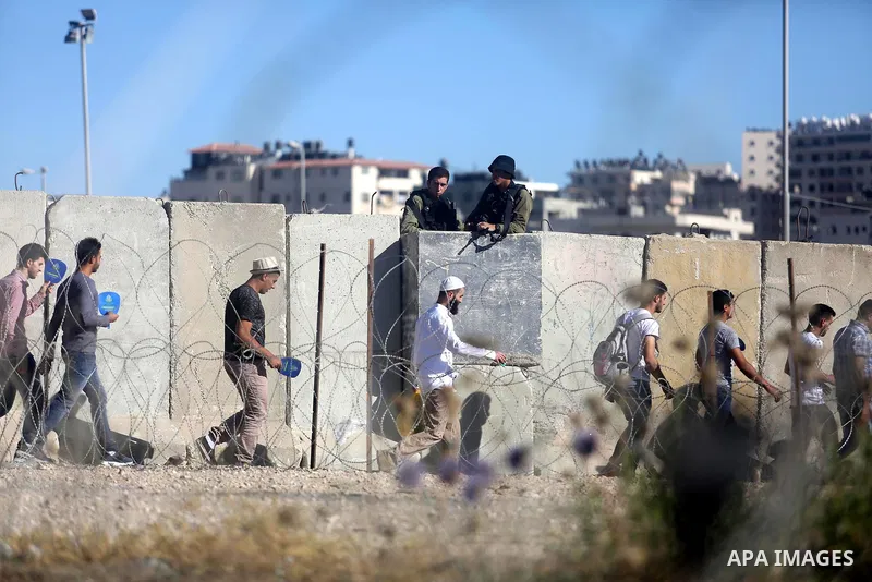 Palestinians make their way through the Israeli Qalandia checkpoint, in the occupied West Bank between Ramallah and Jerusalem, to attend Friday prayer of the holy fasting month of Ramadan in Jerusalem's al-Aqsa mosque, o...