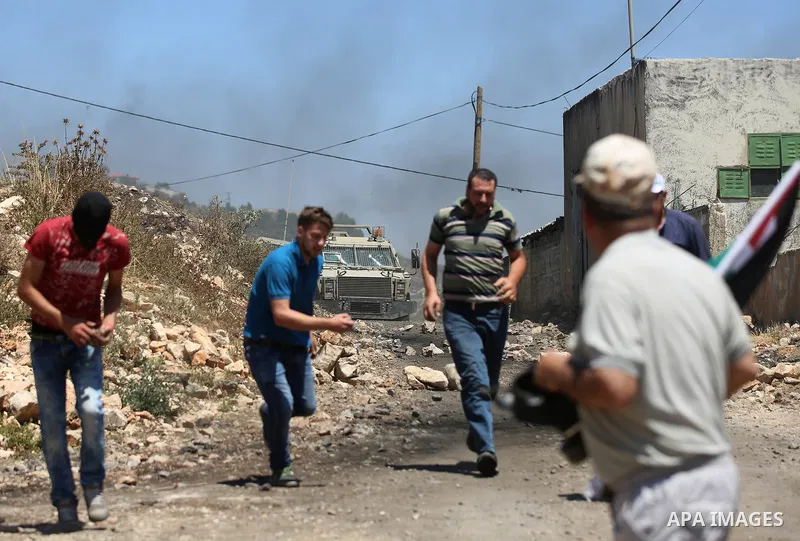 Palestinian protesters hurl stones towards Israeli security forces during clashes following a demonstration against the expropriation of Palestinian land by Israel in the village of Kfar Qaddum, near Nablus, in the occup...