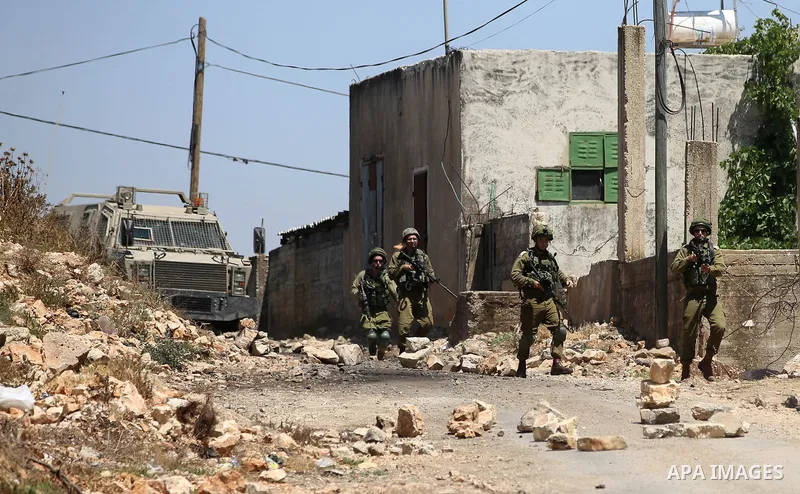 Israeli security forces aim their weapons towards Palestinian protesters during clashes following a demonstration against the expropriation of Palestinian land by Israel in the village of Kfar Qaddum, near Nablus, in the...