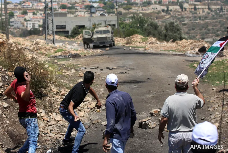 Palestinian protesters hurl stones towards Israeli security forces during clashes following a demonstration against the expropriation of Palestinian land by Israel in the village of Kfar Qaddum, near Nablus, in the occup...