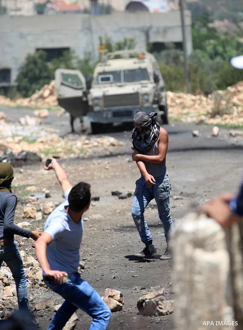 Palestinian protesters hurl stones towards Israeli security forces during clashes following a demonstration against the expropriation of Palestinian land by Israel in the village of Kfar Qaddum, near Nablus, in the occup...