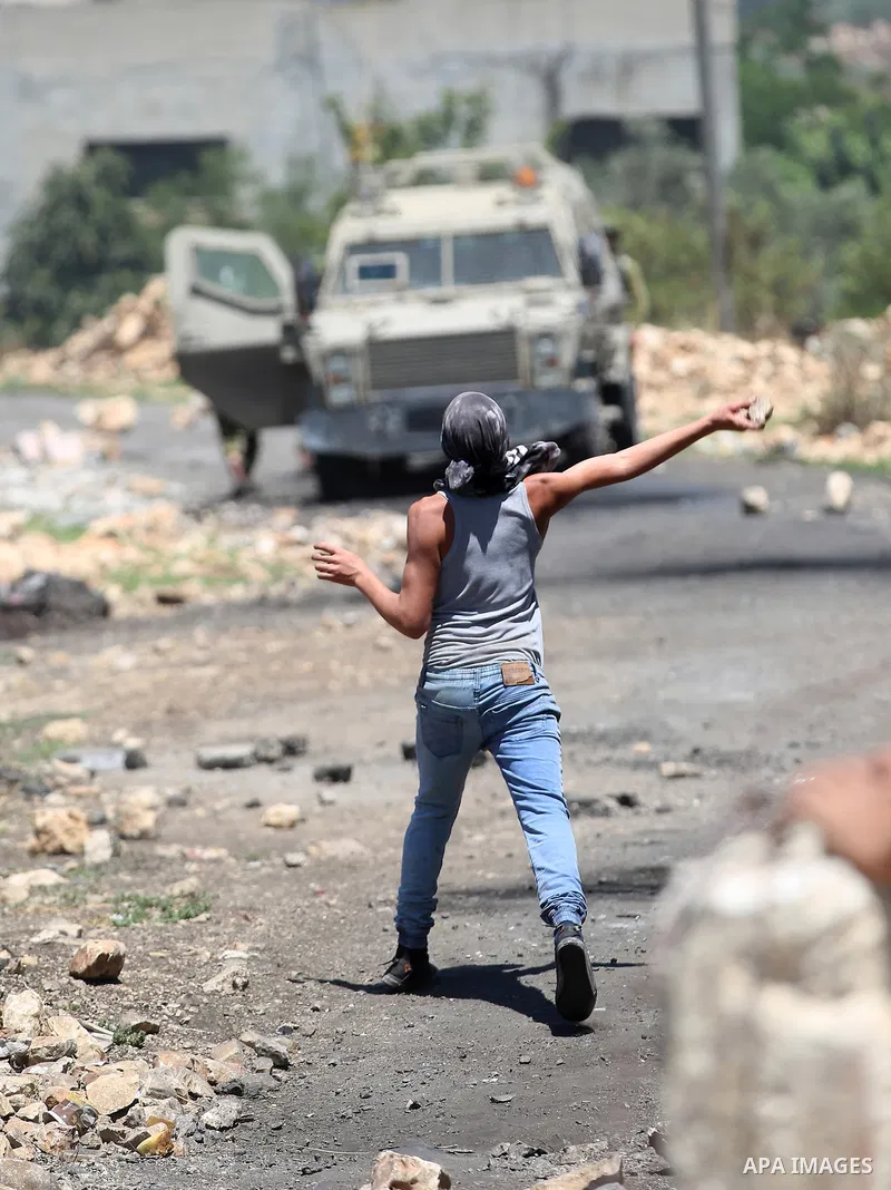 A Palestinian protester hurls stones towards Israeli security forces during clashes following a demonstration against the expropriation of Palestinian land by Israel in the village of Kfar Qaddum, near Nablus, in the occ...