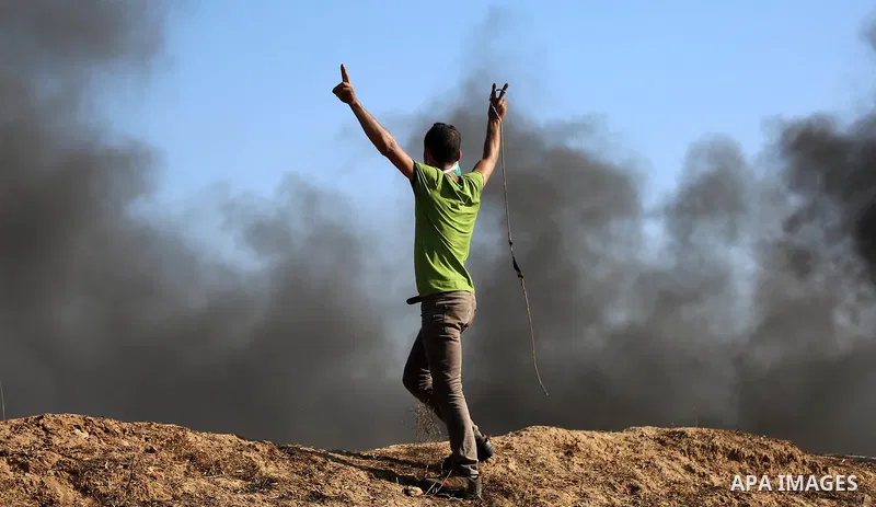 Palestinian protesters take cover during clashes with Israeli security forces following a demonstration against the blockade on the Gaza Strip, near the border fence east of Jabalia refugee camp on June 16, 2017. Photo b...