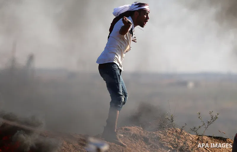 Palestinian protesters take cover during clashes with Israeli security forces following a demonstration against the blockade on the Gaza Strip, near the border fence east of Jabalia refugee camp on June 16, 2017. Photo b...