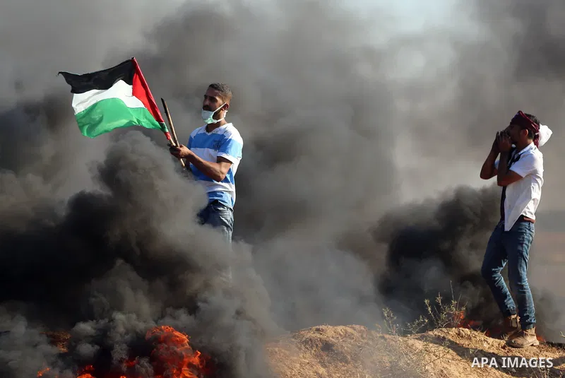 Palestinian protesters take cover during clashes with Israeli security forces following a demonstration against the blockade on the Gaza Strip, near the border fence east of Jabalia refugee camp on June 16, 2017. Photo b...