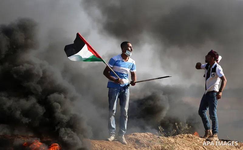 Palestinian protesters take cover during clashes with Israeli security forces following a demonstration against the blockade on the Gaza Strip, near the border fence east of Jabalia refugee camp on June 16, 2017. Photo b...