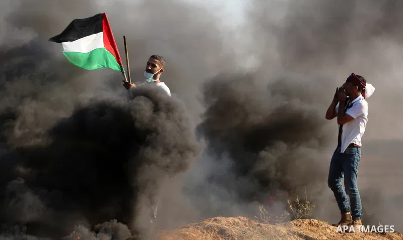 Palestinian protesters take cover during clashes with Israeli security forces following a demonstration against the blockade on the Gaza Strip, near the border fence east of Jabalia refugee camp on June 16, 2017. Photo b...