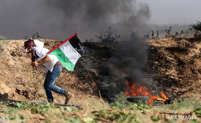 Palestinian protesters take cover during clashes with Israeli security forces following a demonstration against the blockade on the Gaza Strip, near the border fence east of Jabalia refugee camp on June 16, 2017. Photo b...