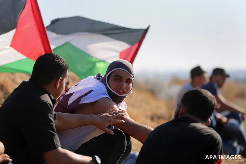 Palestinian protesters take cover during clashes with Israeli security forces following a demonstration against the blockade on the Gaza Strip, near the border fence east of Jabalia refugee camp on June 16, 2017. Photo b...