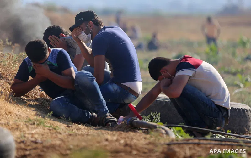 Palestinian protesters take cover during clashes with Israeli security forces following a demonstration against the blockade on the Gaza Strip, near the border fence east of Jabalia refugee camp on June 16, 2017. Photo b...