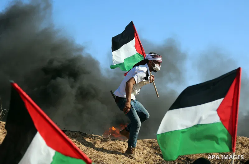 Palestinian protesters take cover during clashes with Israeli security forces following a demonstration against the blockade on the Gaza Strip, near the border fence east of Jabalia refugee camp on June 16, 2017. Photo b...