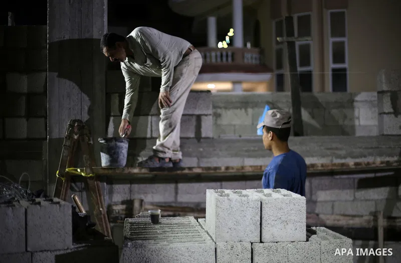 Palestinian labourers work at construction site at night, to avoid the day time heat, on the Muslim holy fasting month of Ramadan in Gaza city on June 17, 2017. Ramadan is sacred to Muslims because it is during that mont...