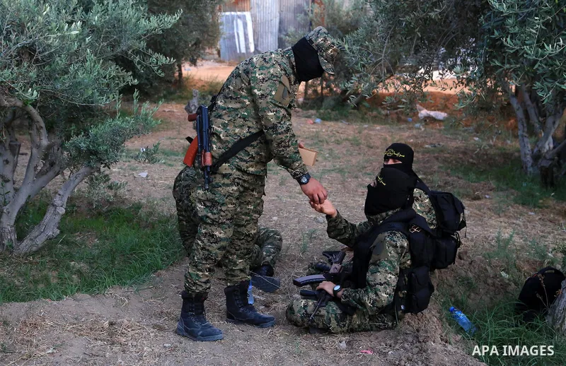 Palestinian militants from the Al-Quds Brigades, the armed wing of the Islamic Jihad movement break their fast as they guard the border between the Gaza Strip and Israel on the Muslim holy fasting month of Ramadan on Jun...