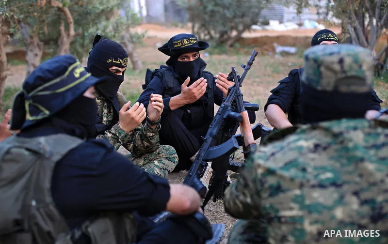 Palestinian militants from the Al-Quds Brigades, the armed wing of the Islamic Jihad movement perform prayer as they guard the border between the Gaza Strip and Israel on the Muslim holy fasting month of Ramadan on June...