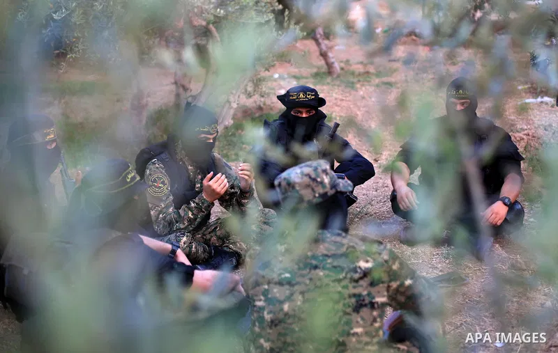 Palestinian militants from the Al-Quds Brigades, the armed wing of the Islamic Jihad movement perform prayer as they guard the border between the Gaza Strip and Israel on the Muslim holy fasting month of Ramadan on June...