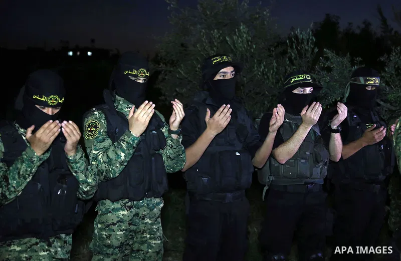 Palestinian militants from the Al-Quds Brigades, the armed wing of the Islamic Jihad movement perform prayer as they guard the border between the Gaza Strip and Israel on the Muslim holy fasting month of Ramadan on June...