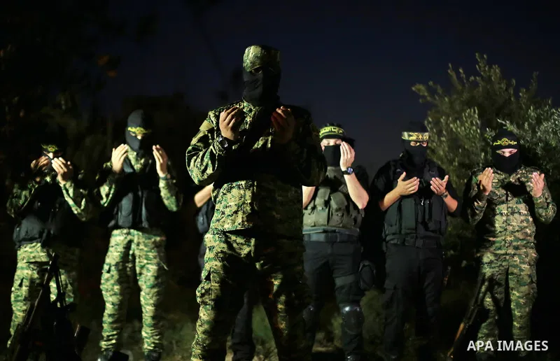 Palestinian militants from the Al-Quds Brigades, the armed wing of the Islamic Jihad movement perform prayer as they guard the border between the Gaza Strip and Israel on the Muslim holy fasting month of Ramadan on June...