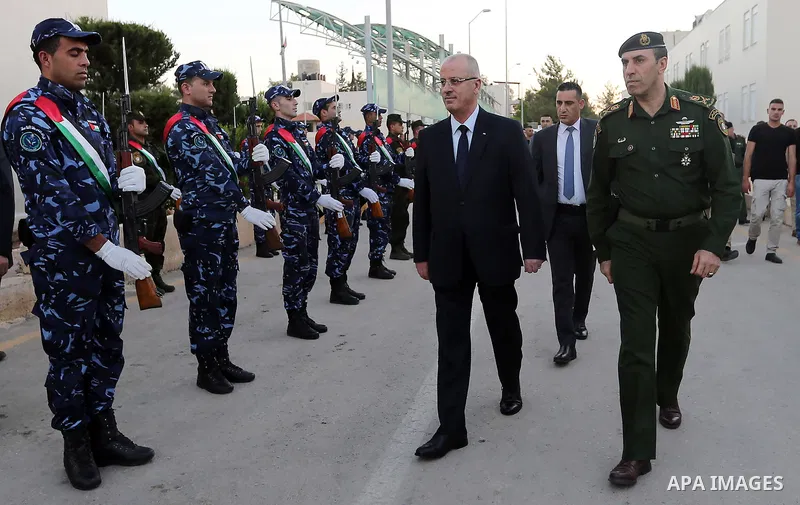 Palestinian Prime Minister Rami Hamdallah reviews the honor guards as he arrives to breakfasting with security forces on the Muslim holy fasting month of Ramadan, in the West Bank city of Jenin on June 18, 2017. Photo by...