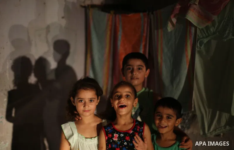 Palestinian children pose a photo during a power cut, outside their house at Al-Shate' refugee camp, in Gaza city on June 19, 2017. Photo by Mohammed Asad