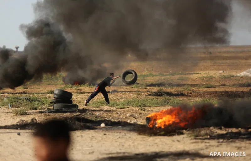 Palestinians react to tear gas fired by Israeli troops during clashes at a protest against reducing power supply to Gaza, near the border with Israel in Khan Younis in the southern Gaza Strip June 20, 2017. Photo by Ashr...