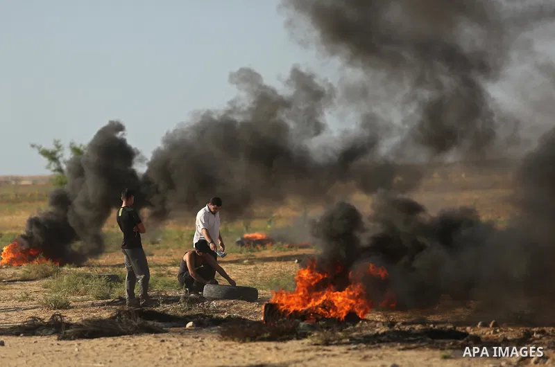Palestinians react to tear gas fired by Israeli troops during clashes at a protest against reducing power supply to Gaza, near the border with Israel in Khan Younis in the southern Gaza Strip June 20, 2017. Photo by Ashr...