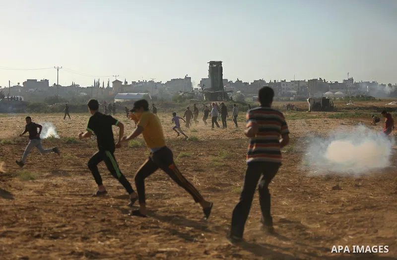 Palestinians react to tear gas fired by Israeli troops during clashes at a protest against reducing power supply to Gaza, near the border with Israel in Khan Younis in the southern Gaza Strip June 20, 2017. Photo by Ashr...