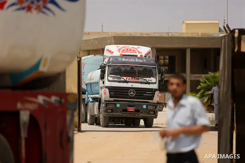 A member of Palestinian security forces stands guard as trucks carrying fuel enter the southern Gaza Strip from Egypt through the Rafah border crossing on June 21, 2017. Egypt began to deliver a million litres of fuel to...