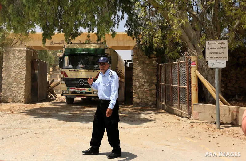 A member of Palestinian security forces stands guard as trucks carrying fuel enter the southern Gaza Strip from Egypt through the Rafah border crossing on June 21, 2017. Egypt began to deliver a million litres of fuel to...