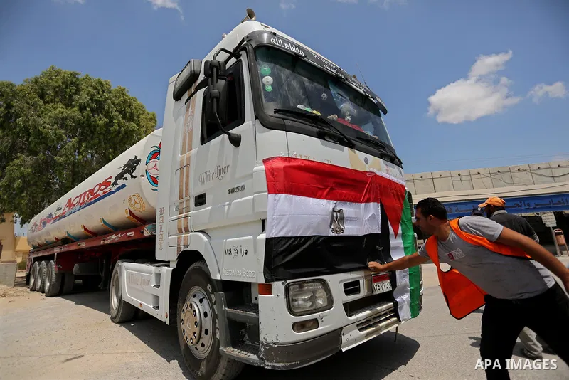 Palestinians put the national flag and Egyptian flag on an Egyptian truck carrying fuel after it was enter the southern Gaza Strip from Egypt through the Rafah border crossing on June 21, 2017. Egypt began to deliver a m...