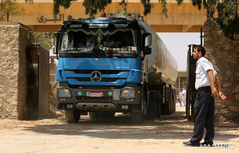 A member of Palestinian security forces stands guard as Egyptian trucks carrying fuel enter the southern Gaza Strip from Egypt through the Rafah border crossing on June 21, 2017. Egypt began to deliver a million litres o...